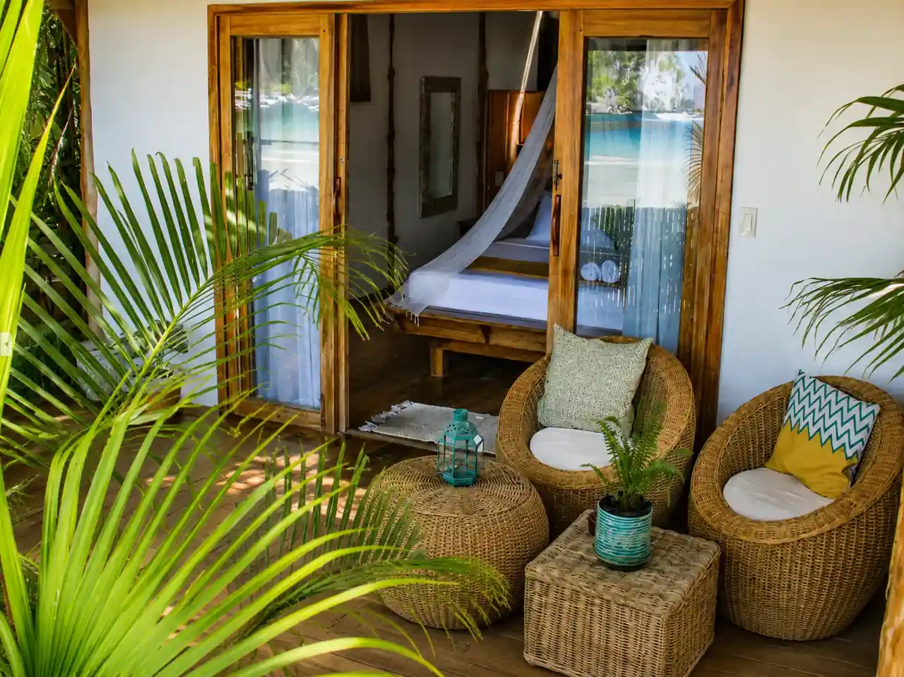 Private bungalow veranda with wicker seating opening onto the bedroom at Maligaya Beach Bungalows